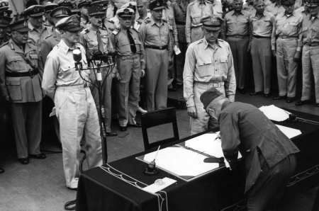 Japānas ģenerālis Jošidžiro Umezo paraksta kapitulācijas dokumentu uz “Missouri” klāja Tokijas līcī 1945. gada 2. septembrī.