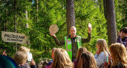 Daugmales skolēni ar interesi klausās LVM darbinieku stāstos par norisēm mežā.
