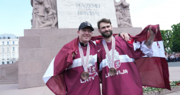 Latvijas hokeja izlases spēlētājs Ronalds Ķēniņš (no kreisās) un vārtsargs Ivars Punnenovs pie Brīvības pieminekļa 2023. gada 29. maijā.