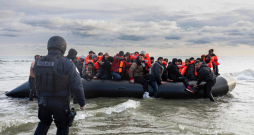 Francijas policisti ar nažiem mēģina pārdurt cilvēku kontrabandistu sagādāto laivu, lai neļautu migrantiem doties dzīvībai bīstamā braucienā pāri Lamanšam uz Lielbritāniju. Nelegālās migrācijas jautājums pēdējos gados kļuvis par vienu no visvairāk apspriestajiem Eiropā.