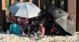 Migranti jau pēc Meksikas un ASV robežas šķērsošanas pie robežas žoga gaida Savienoto Valstu robežsargus.