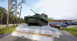 Kadagā pie Nacionālo bruņoto spēku NBS militārās bāzes uz podesta izvietotais kāpurķēžu bruņutransportieris.