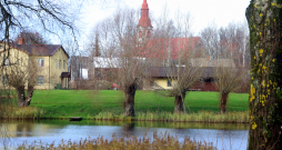Aiz Dzirnavu ezera pakalna panorāmā redzama Lēdurgas Ev. luteriskā baznīca.