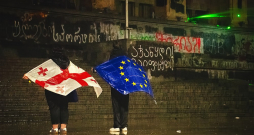 Protesta dalībnieces ar Gruzijas un Eiropas Savienības karogiem pie Gruzijas parlamenta 2024. gada decembrī.