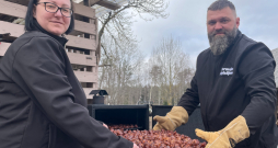 Purmaļu saimnieki rāda tikko nokūpinātās vistu astītes, pēc kurām tirgū ir liels pieprasījums.