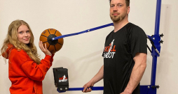 Jānis Gremzde ar meitu Skārletu pie basketbola metiena trenažiera.