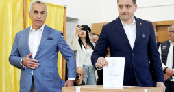 Rumānijas prezidenta amata kandidāts Džordže Simions (no labās) svētdien vēlēšanu iecirknī ieradās kopā ar pērnā gada anulēto vēlēšanu pirmās kārtas uzvarētāju Kelinu Džordžesku.