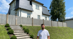 Jānis Vilciņš pie sava nama ar ieeju no Raiņa ielas.