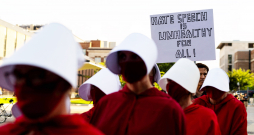 Protestētāji, tērpušies seriāla “Kalpones stāsts” kostīmos, pie Minesotas Universitātes Nortropa auditorijas Mineapolē 2025. gada 22. septembrī, kur notika “American Comeback Tour” pasākums. To vadīja politiskais komentētājs Maikls Noulss pēc tam, kad šī mēneša sākumā tika nogalināts Čārlijs Kērks.