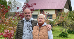 Aija Dzintra un Dainis Paukšēni 20 gados spējuši iekopt bagātīgu
ogulāju dārzu, kurā aug un ražo arī neparastāki augi. Attēlā: saimnieki savā dārzā, aiz muguras redzama māja, kurā ierīkota telpa ekskursantu grupu uzņemšanai.