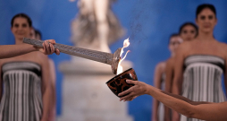 Milānas–Kortīnas olimpisko spēļu uguns tika iedegta, atkāpjoties no tradīcijām, jo bija bažas par nelabvēlīgiem laika apstākļiem.