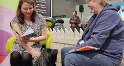 Bērnu grāmatu autore Emilija Tolvanena (no kreisās) un sunīte klausītāja Hloja ar instruktori Helsinku grāmatu izstādes klausītājsuņu stendā. Bērnu grāmatu autore Emilija Tolvanena (no kreisās) un sunīte klausītāja Hloja ar instruktori Helsinku grāmatu izstādes klausītājsuņu stendā.