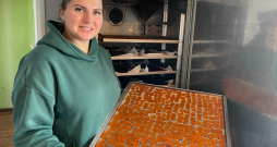 Dienu un nakti mājas virtuvē darbojas žāvētava. Attēlā: saimniece no žāvētavas izņem kārtējo gatavo konfekšu plāti.