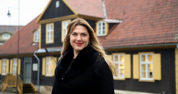 Kuldīgas novada domes priekšsēdētāja Inese Astaševska ar veco Kuldīgas rātsnamu fonā.