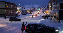 Sieviete tīra savu automašīnu no sniega Nūkā, Grenlandē.