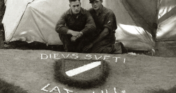 Internētie latviešu leģionāri pie pašdarināta rotājuma – latviešu leģiona vairodziņa. Ēkšes – Rennesletes nometne, 1945. gada
vasara.