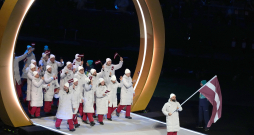 Latvijas karognesējs 2026. gada ziemas olimpiskajās spēlēs, hokejists Kaspars Daugaviņš (no labās) un Latvijas delegācijas sportisti 2026. gada Milānas un Kortīnas ziemas olimpisko spēļu atklāšanas ceremonijā "San Siro" stadionā Milānā, Itālijā.