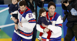 ASV izlases hokejisti Dilans Larkins (no kreisās) un Zaks Verenskis ar traģiski bojā gājušā bijušā komandas biedra Džonija Gudro bērniem pirms čempionu kopbildes.