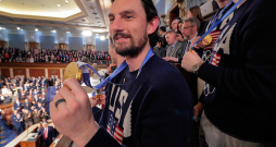 Hokeja fināla varonis vārtsargs Konors Helebaks ASV kongresmeņiem demonstrē savu olimpisko zelta medaļu.