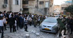 Izraēlas pirmās palīdzības dienestu darbinieki ierodas vietā, kur Telavivas piepilsētas rajonā 2026. gada 28. februārī nokritušas raķešu pārtveršanas laikā radušās atlūzas.