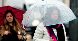 Cilvēki lietus laikā Rīgā.
