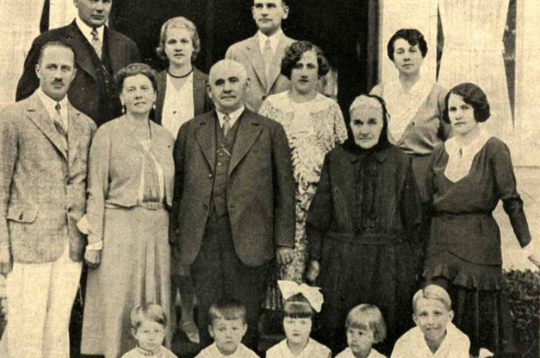 A. Benjamiņš ar ģimeni. Grupas vidū – pa kreisi sieva Emīlija, viņai blakus – Jānis Benjamiņš. No Antona pa labi – Ede Simsone, tālāk Marta Čakste, dzim. Benjamiņa. Pēdējā rindā (no kreisās): Mintauts Čakste, Annija Simsone, pulkv.-leitn. Ed. Kuplais, viņa dzīvesbiedre Anna Kuplais, dzim. Benjamiņa, viņai blakus – Tusnelda Simsone. Priekšā (no labās): Žoržs Benjamiņš, Maija Kuplais. Aija Čakste, Jānis Čakste, Peters Aihers. 