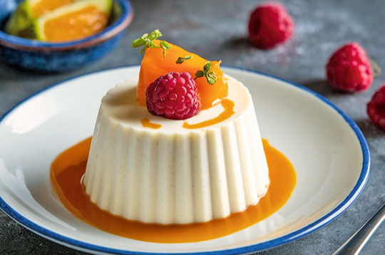 Vaniļas panna cotta ar persikiem.