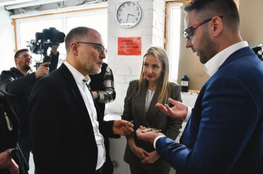 Ražošanas vadītājs Lauris Stafeckis (no labās) un Beāte Krauze-Čebotare aizsardzības ministru Andri Sprūdu iepazīstina ar munīcijas ražotnes "Ammunity" darbību.