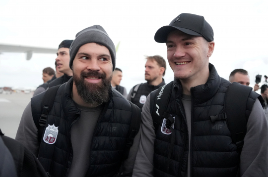 Latvijas hokeja izlases spēlētāji Kaspars Daugaviņš (no kreisās) un Kristaps Roberts Zīle Rīgas lidostā pirms došanās uz 2025. gada pasaules hokeja čempionātu Stokholmā.