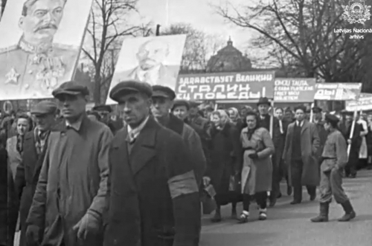 Rīdzinieki 1945. gada 9. maijā organizēti dodas uz centrālo mītiņu Rīgā. Kinožurnālā “Padomju Latvija" diktora teksts: “Ļaudis līksmos gājienos devās uz Esplanādi.”