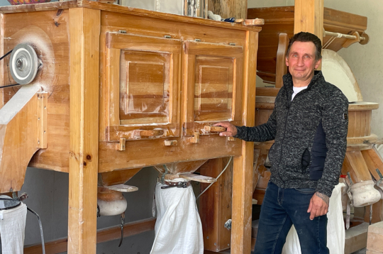 “Kaņepīšu” saimnieks Guntars Antonijs pie akmens dzirnavām, kurās maļ 12 dažāda smalkuma miltus.