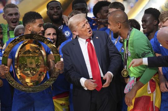 Prezidents Donalds Tramps (centrā) sarunājas ar "Chelsea" vārtsargu Robertu Sančesu (pa labi), kamēr "Chelsea" spēlētājs Rīss Džeimss tur čempionu trofeju pēc Klubu pasaules kausa fināla futbola spēles starp "Chelsea" un Parīzes "Saint-Germain" MetLife stadionā Īstraterfordā, Ņūdžersijā, svētdien, 2025. gada 13. jūlijā.