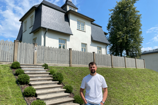 Jānis Vilciņš pie sava nama ar ieeju no Raiņa ielas.