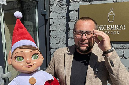 Kristaps Štobis ar "December Design" talismanu – elfu, ko kolēģi iesaukuši par Borisu. "Boriss nekad nav atstājis mūsu biroja telpas, bet viņa vecāko brāli jau vairākus gadus Ziemassvētku laikā var satikt Liepājā, lidojot gaisa balonā."