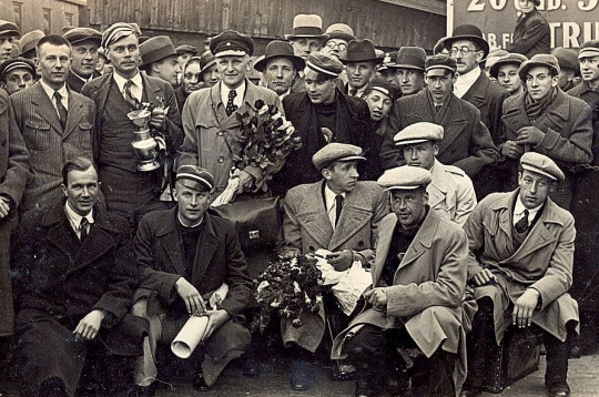 Latvijas basketbola izlases sagaidīšana Rīgas dzelzceļa stacijā 1935. gada 8. maijā. Priekšplānā J. Lidmanis. No kreisās 1. rindā – R. Dekšenieks, E. Andersons, M. Grundmanis, V. Melderis, A. Anufrijevs. 2. rindā pirmais – Dž. Raudziņš, komandas kapteinis R. Jurciņš ar izcīnīto kausu – sudraba vīna trauku, Kristaps Voldemārs Baumanis.