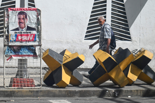 Vīrietis iet garām Venecuēlas prezidenta Nikolasa Maduro plakātam un prettanku barjerai Karakasā, 2025. gada 28. oktobrī. ASV spēki nogalināja 14 cilvēkus triecienos, kas iznīcināja četras, kā tiek apgalvots, narkotiku kontrabandā iesaistītas laivas Klusā okeāna austrumu daļā, otrdien paziņoja aizsardzības ministrs Pīts Hegsets. Vīrietis iet garām Venecuēlas prezidenta Nikolasa Maduro plakātam un prettanku barjerai Karakasā, 2025. gada 28. oktobrī. ASV spēki nogalināja 14 cilvēkus triecienos, kas iznīcināja četras, kā tiek apgalvots, narkotiku kontrabandā iesaistītas laivas Klusā okeāna austrumu daļā, otrdien paziņoja aizsardzības ministrs Pīts Hegsets.