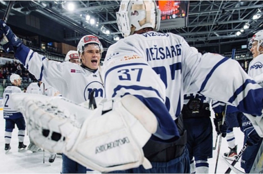 "Mogo/RSU" spēlētāji ar uzvaru apsveic komandas vārtsargu Kārli Mežsargu.