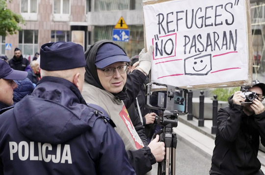 Protestējot pret ukraiņu bēgļiem, vīrietis Varšavā 10. maijā tur plakātu "Bēgļi cauri netiks".