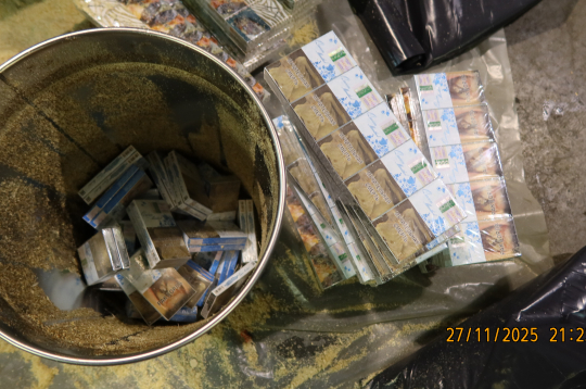 Spaiņos sabērtas zāģskaidas, bet zem tām — dažādu marku cigaretes.