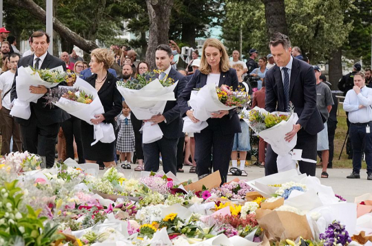 Austrālijā ebreju svētkos nogalinātos pirmdien pieminēja arī politiķi. Pirmais no labās – Jaundienvidvelsas štata, kur atrodas Sidneja, premjers Kriss Minnss. Austrālijā ebreju svētkos nogalinātos pirmdien pieminēja arī politiķi. Pirmais no labās – Jaundienvidvelsas štata, kur atrodas Sidneja, premjers Kriss Minnss.