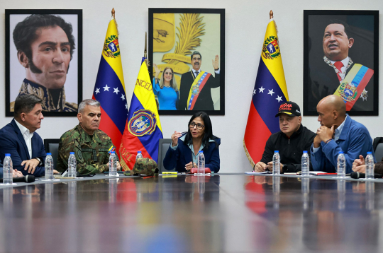 Šajā Mirafloresas pils preses dienesta izplatītajā fotoattēlā redzama Venecuēlas viceprezidente Delsija Rodrigesa (centrā), kura uzrunā klātesošos līdzās Venecuēlas aizsardzības ministram Vladimiram Padrino Lopesam (otrais no kreisās) un Venecuēlas iekšlietu, tieslietu un miera ministram Diosdado Kabello (otrais no labās) Ministru padomes sēdes laikā viceprezidentūras ēkā Karakasā 2026. gada 4. janvārī.