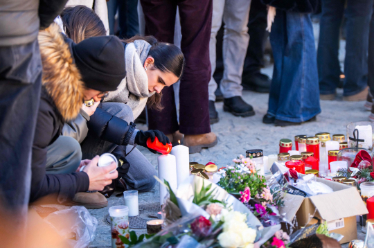 Sērotāji iededz sveces, pulcējoties pie improvizēta piemiņas memoriāla, lai noliktu ziedus, sveces un atvadu vēstījumus pie bāra Constellation 2026. gada 4. janvārī Kranmontanā, pieminot Jaungada naktī notikušā ugunsgrēka upurus greznajā Alpu slēpošanas kūrortā.