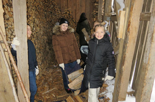 Malku no šķūnīša uz skolas ēku nes Aksels (no kreisās), Daniela un Melānija.