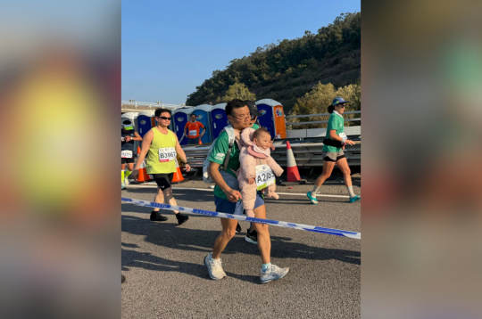 Maratona dalībnieks ar zīdaini.