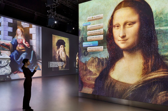 Izmantojot interaktīvas tehnoloģijas un projekcijas, ikoniskais mākslas šedevrs "Mona Liza" (priekšplānā) tiek atklāts jaunā aizraujošā veidā.
