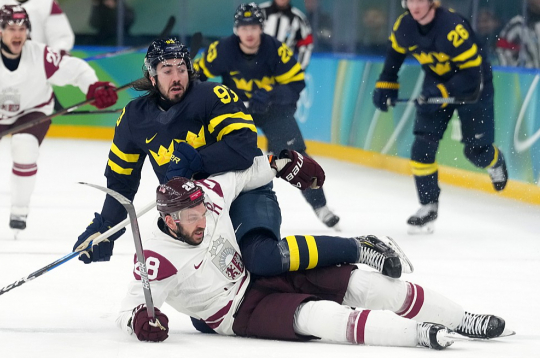 Zviedrijas izlases spēlētājs Mika Zibanedžads cenšas "apseglot" Zemgu Girgensonu, kurš bija labākais Latvijas izlases hokejists olimpiskajā turnīrā.