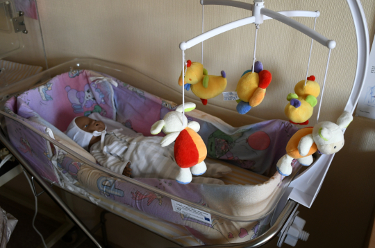 Lelle bērnu gultiņā.