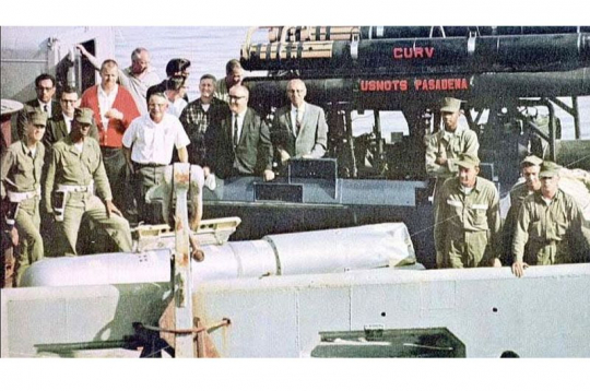 Izceltā ūdeņraža bumba (pelēkā krāsā) uz ASV kuģa klāja. Izceltā ūdeņraža bumba (pelēkā krāsā) uz ASV kuģa klāja.