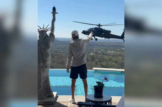 Mūziķis Kid Rock salutē ASV militārajam helikopteram. Mūziķis Kid Rock salutē ASV militārajam helikopteram.