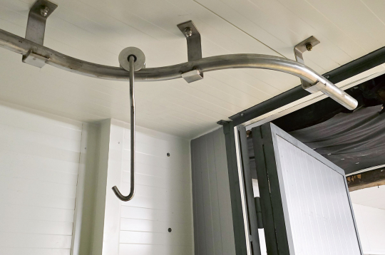 Dzesētavas griestos ir iestrādāti speciāli jaudīgi metāla stiprinājumi, pie kuriem ir pieskrūvētas apmēram septiņu centimetru diametra nerūsējošā tērauda caurules. Papildus ir izgatavoti jaudīgi āķi ar tērauda skritulīšiem, kas brīvi un bez aiztures ripo pa šīm caurulēm. 